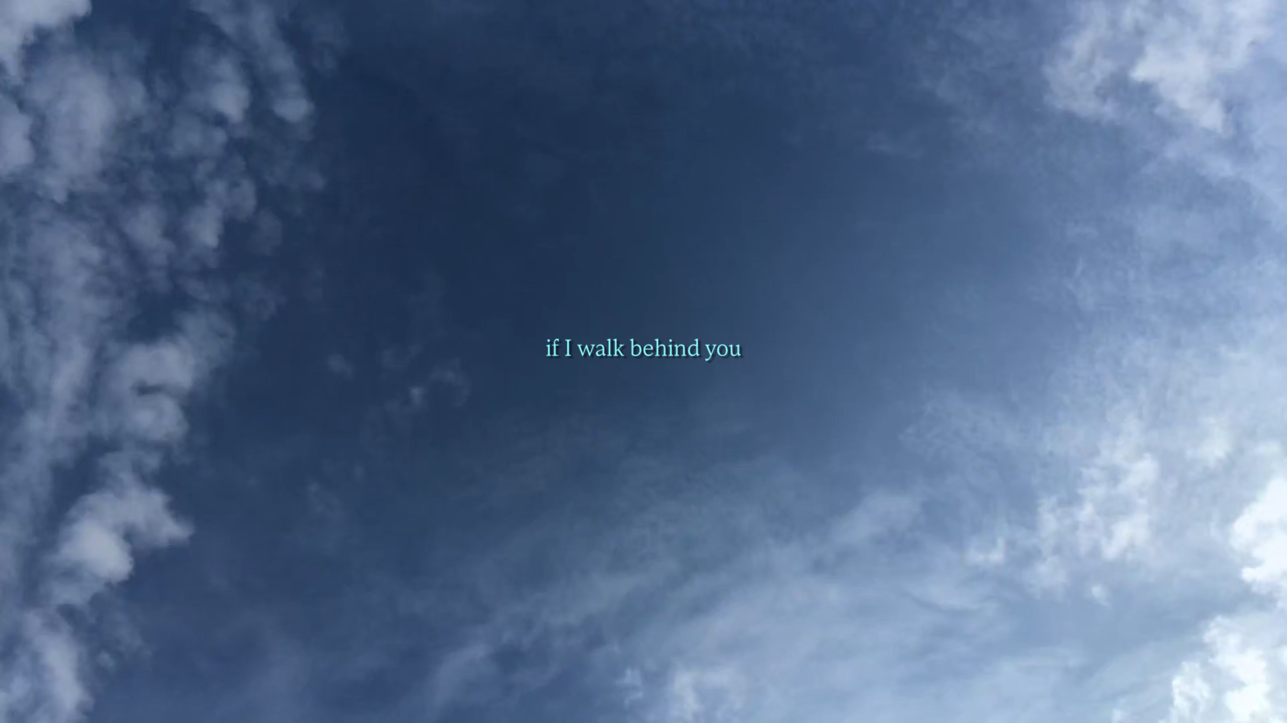 Image shows a screenshot of a blue sky with light clouds. Turquoise writing is imposed over the top, which reads, if I walk behind you